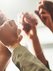 O que é Solidariedade? A imagem mostra diversas mãos se entrelaçando, simbolizando a união e o esforço coletivo para enfrentar desafios e construir um futuro melhor.
