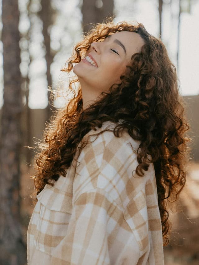 Uma pessoa meditando em um ambiente sereno, com raios de sol iluminando seu rosto.