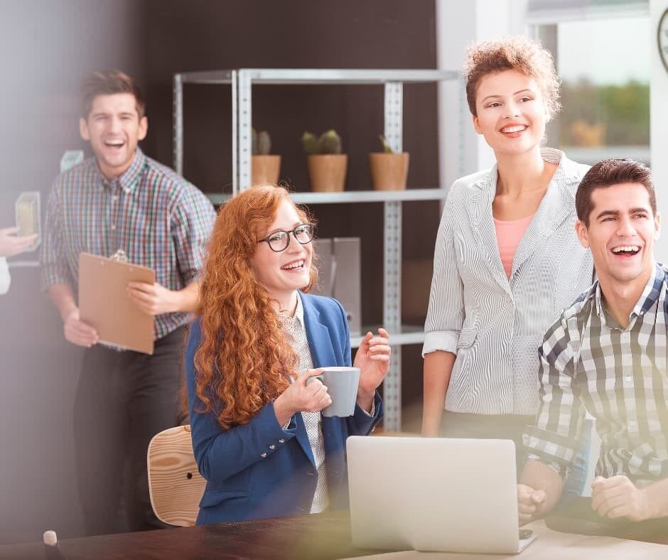 Ambiente de trabalho colaborativo, com profissionais utilizando laptops e pranchetas, cercados por xícaras de café, simbolizando produtividade e inovação. Imagem do artigo "Trabalho Motivado: O Início", da categoria "Trabalho Motivado". Ideal para conteúdos sobre colaboração, motivação no trabalho e estratégias de crescimento profissional.