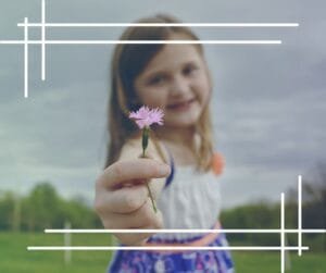 Criança segurando uma pequena flor em um campo verde, simbolizando a beleza da infância e a importância de valorizar momentos simples. Imagem da "Capa da Web Story" do artigo "Expectativas: Frustrações em Potencial", pertencente à categoria "Desenvolvimento Pessoal" e subcategoria "Desenvolvimento Emocional".