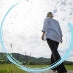 Pessoa caminhando por uma trilha em direção ao horizonte, simbolizando foco e direção.