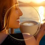 Pessoa sorrindo enquanto aprecia uma xícara de café ao nascer do sol