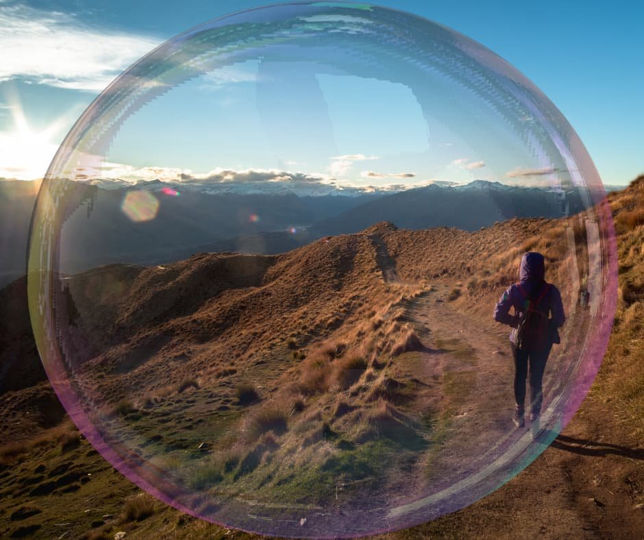 Pessoa caminhando por uma trilha montanhosa ao amanhecer, simbolizando perseverança, adaptação e continuidade.