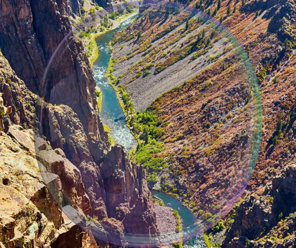 Rio contornando grandes pedras em meio à natureza, simbolizando adaptação, perseverança e sabedoria.